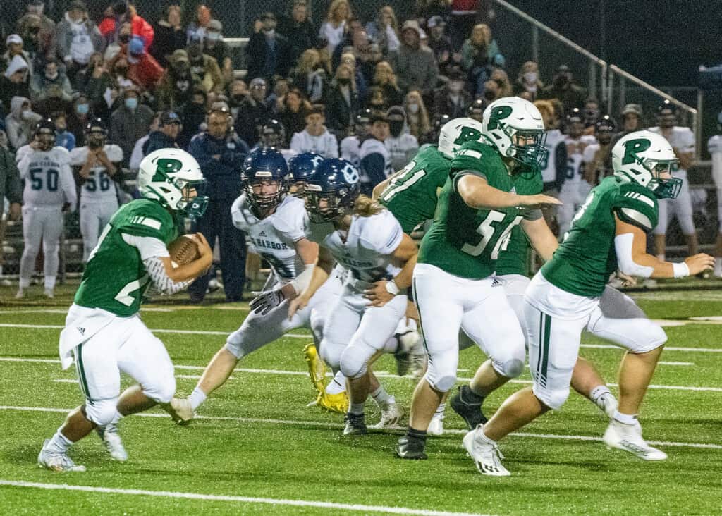 Peninsula's Ethan Hogan is escorted around the right side by Seahawk blockers.