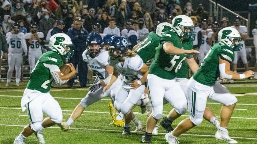 Peninsula's Ethan Hogan is escorted around the right side by Seahawk blockers.