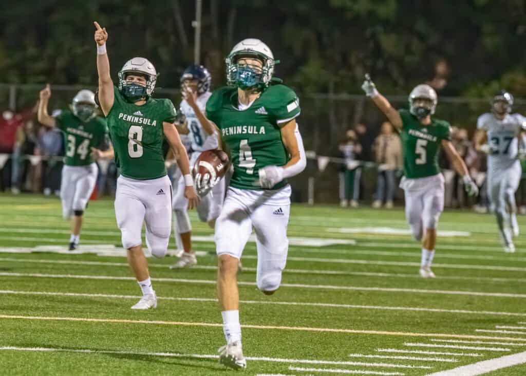 Ethan Fias nears the end zone, accompanied by exultant Seahawks, on an 86-yard interception return.