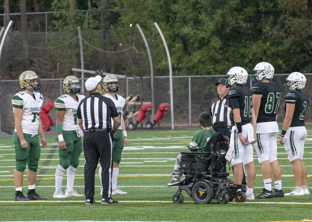 Micah Hester and team captains from Peninsula and Timberline watch the coin flip before Friday's game.