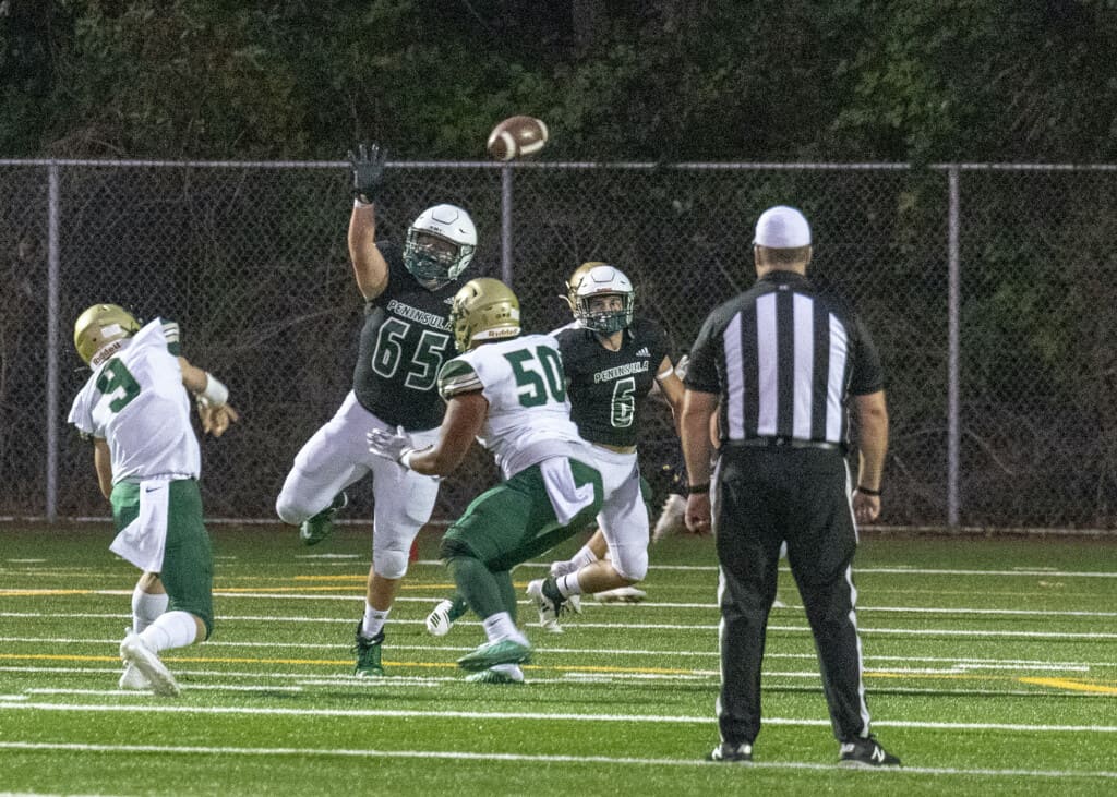 Peninsula’s Taylor Jones (65) tries to bat down a pass from Timberline quarterback Jackson Brown (9).