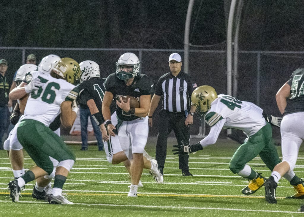 Josh Hinkel (2) looks for running room between Timberline defenders.