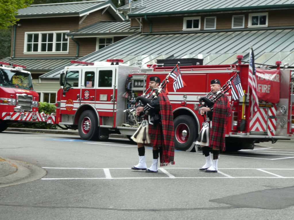 GHFMO bagpipers Mike Metters, left, and TJ Freeby open the 9/11 event in front of a fire engine.