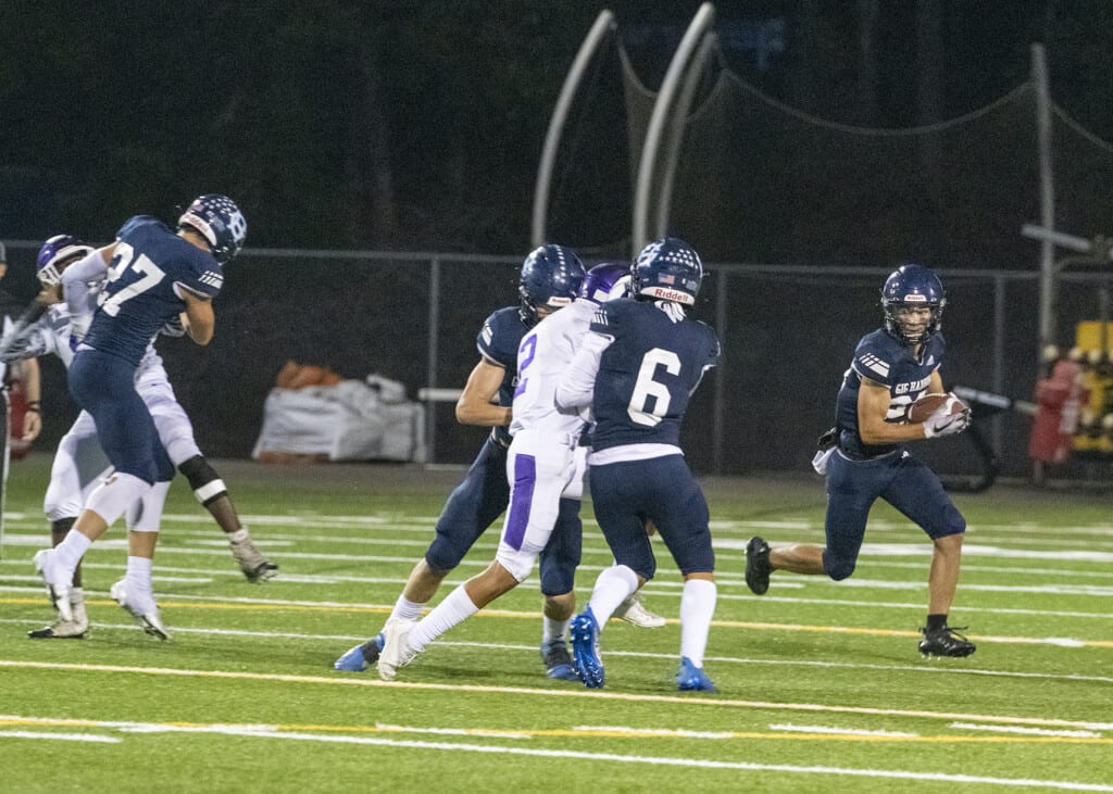 A Gig Harbor running back looks for daylight around the left side.