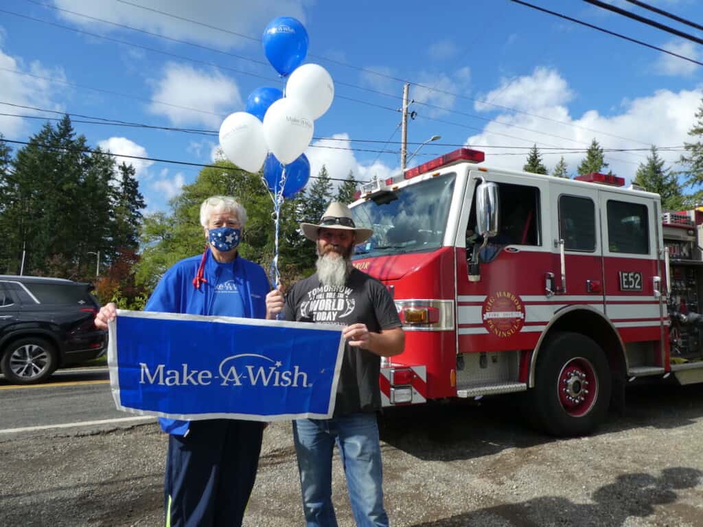 Make-a-Wish volunteer Ken Kieffer (left) and Brett Colglazier are ready for the presentation of a new golf cart for Colglazier’s son, Oliver.