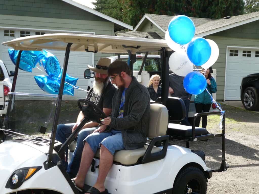 Oliver Colglazier and his dad Brett take the new golf cart for a test drive.