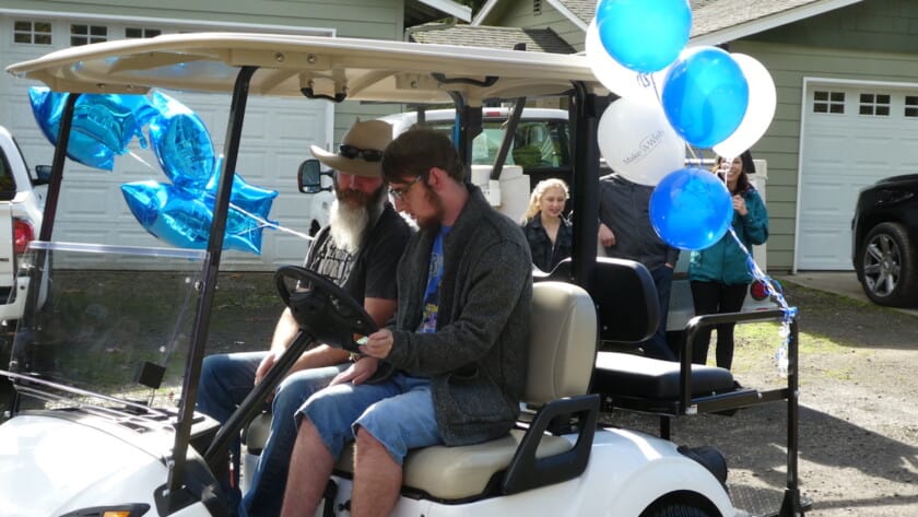 Oliver Colglazier and his dad Brett take the new golf cart for a test drive.