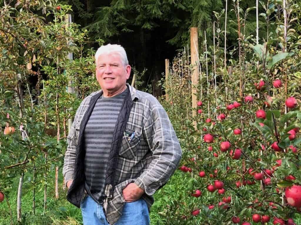 Steve Butler standing in his apple orchard