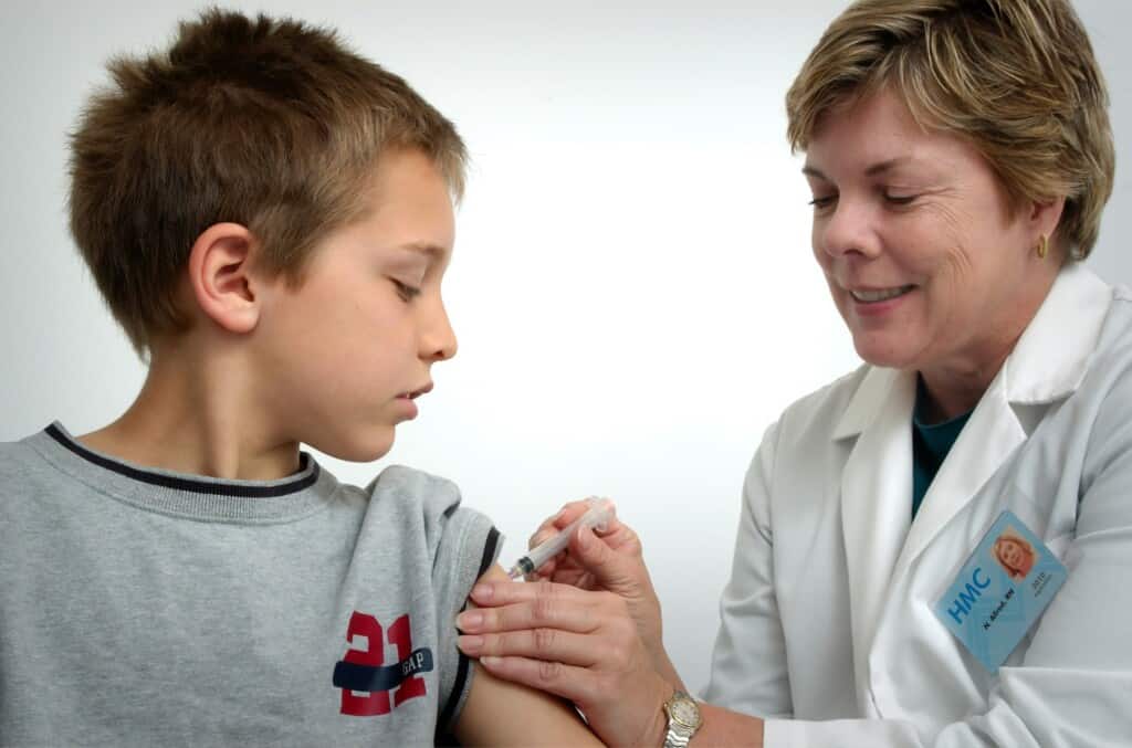 A child getting. vaccine in his shoulder