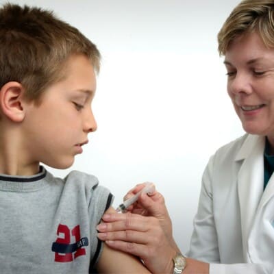 A child getting. vaccine in his shoulder