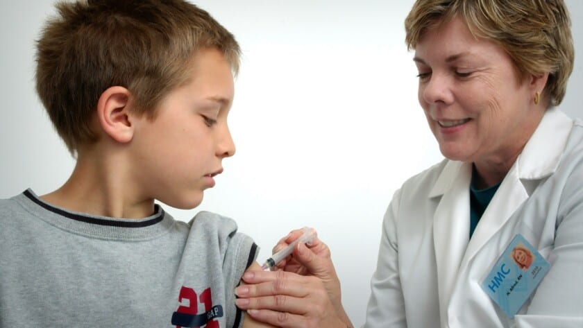 A child getting. vaccine in his shoulder