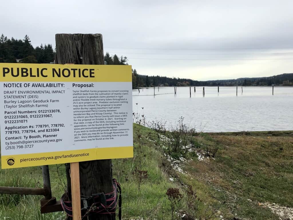 Photo of Burley Lagoon and public notice sign about proposal to farm geoducks