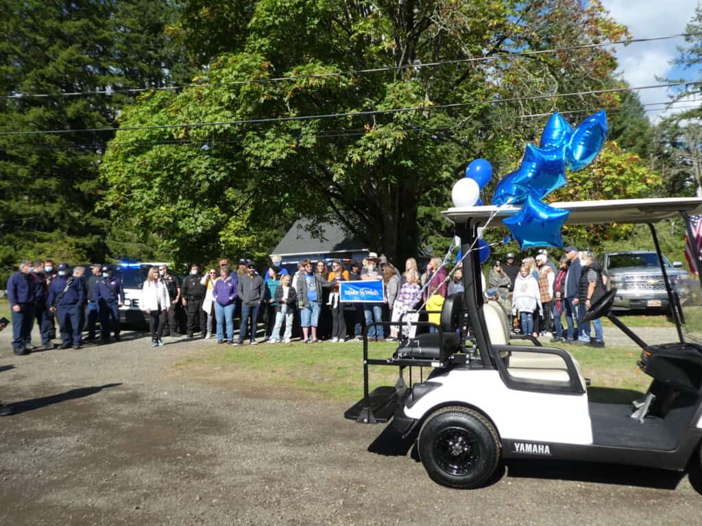 The crowd gathers for a photo with the new golf cart at Oliver Colglazier’s Make-a-WIsh celebration.
