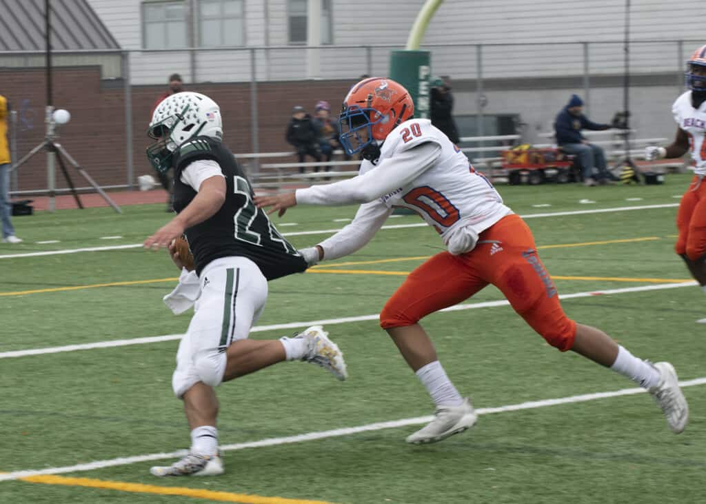 A Rainier Beach defenders tries to pull down Peninsula running back Ethan Hogan by the jersey.