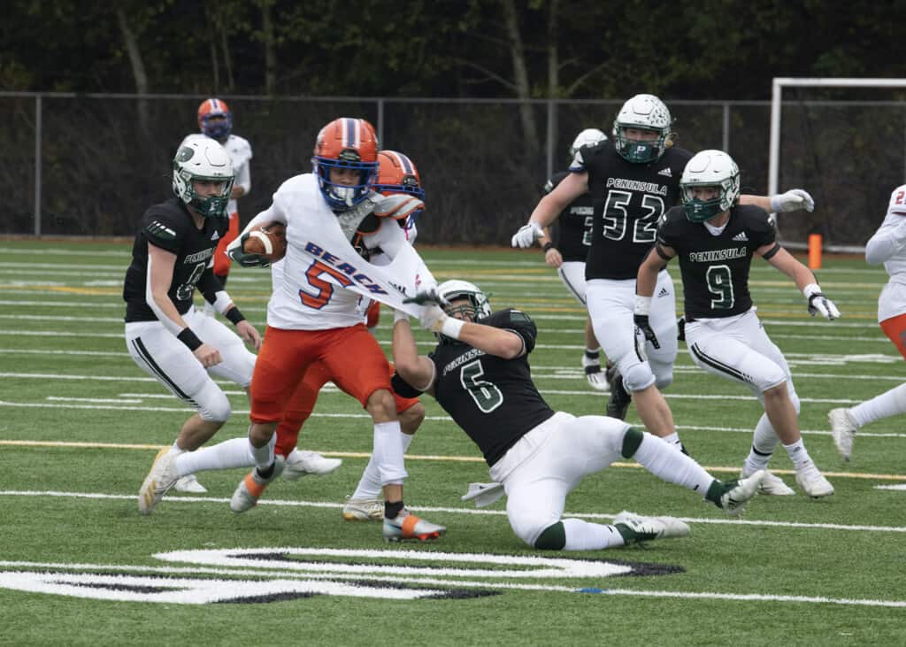 Peninsula's Duren Miller drags down Rainier Beach's Caleb Presley by the shoulder.