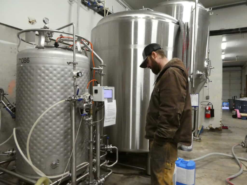 A worker checks gauges on the tanks.