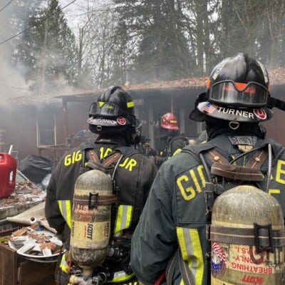 Firefighters outside a burned house