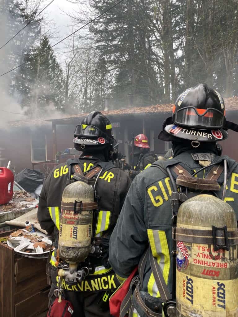 Firefighters outside a burned house