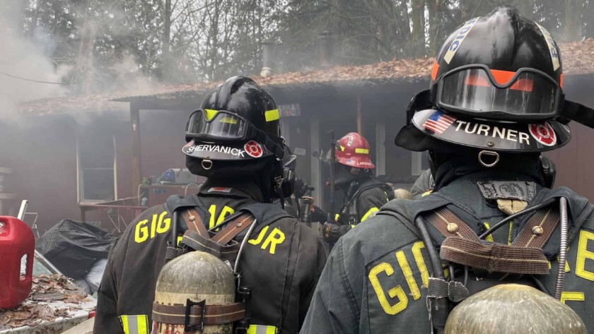 Firefighters outside a burned house