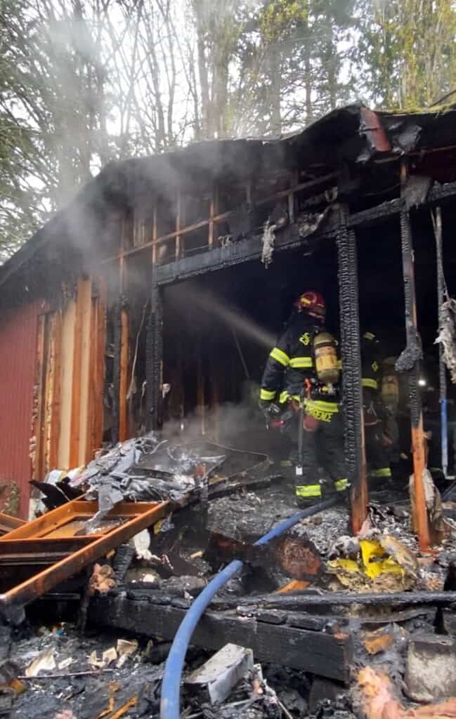 Firefighters hosing down a burning house