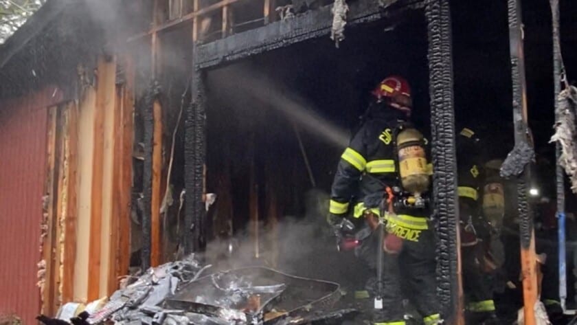 Firefighters hosing down a burning house