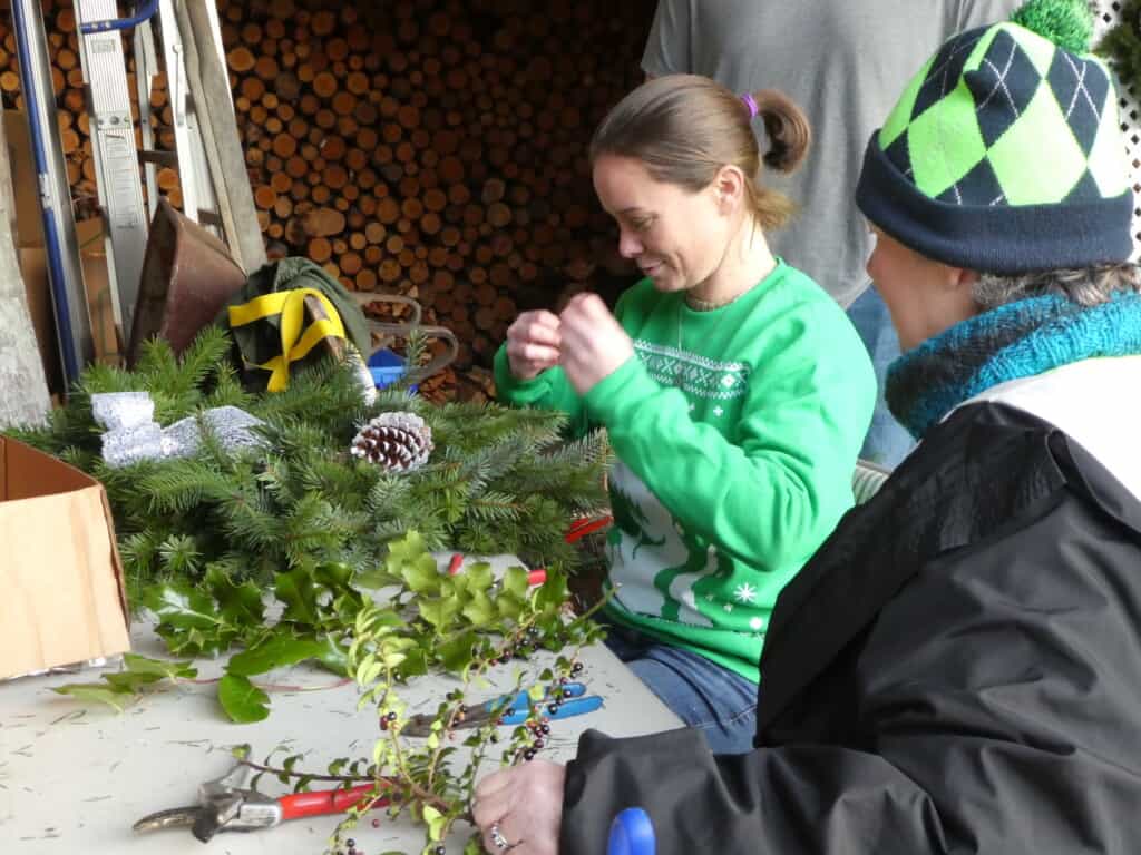 Amanda Edwards makes a wreath as Linda Kingsbury looks on