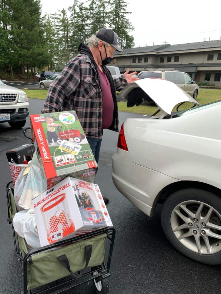 Volunteer Jim Jones packs toys into a car trunk Thursday.