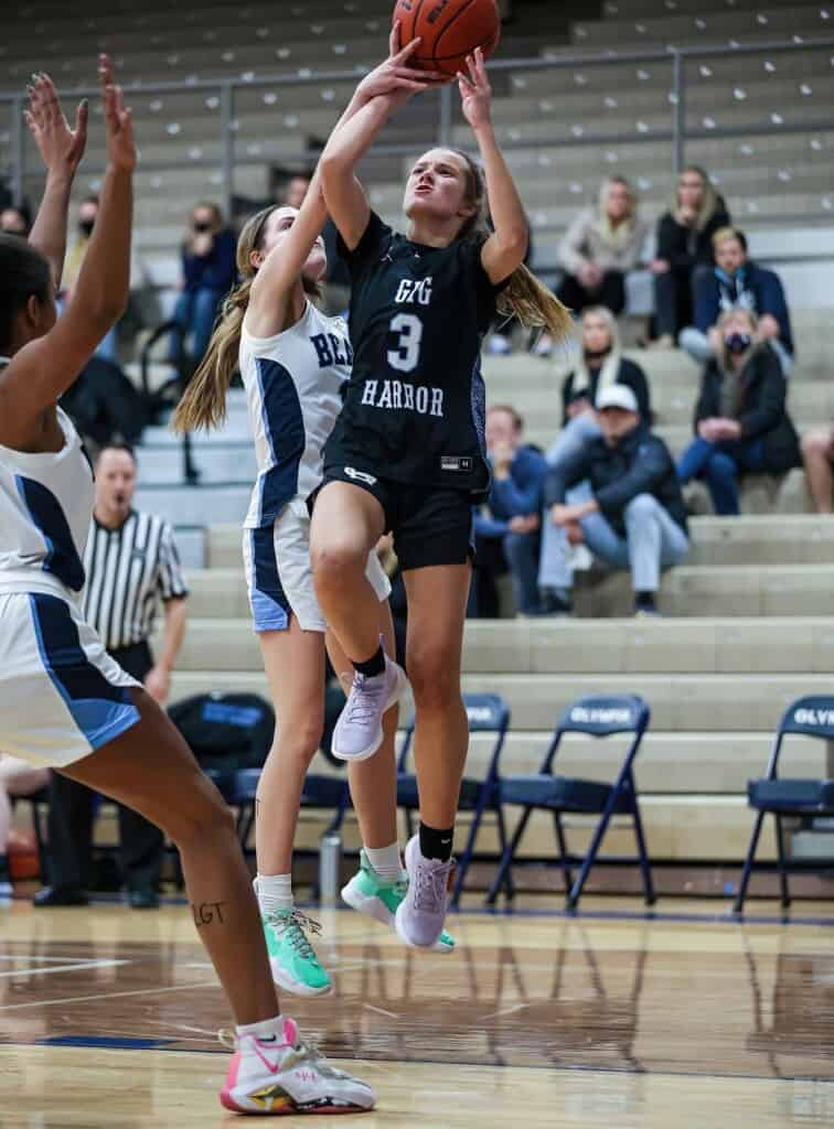 Taylor Schwab gets smacked on the arm while going up for a shot against Olympia.