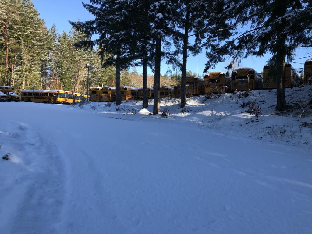 A steep, snow-covered road leading to Peninsula School District's bus barn
