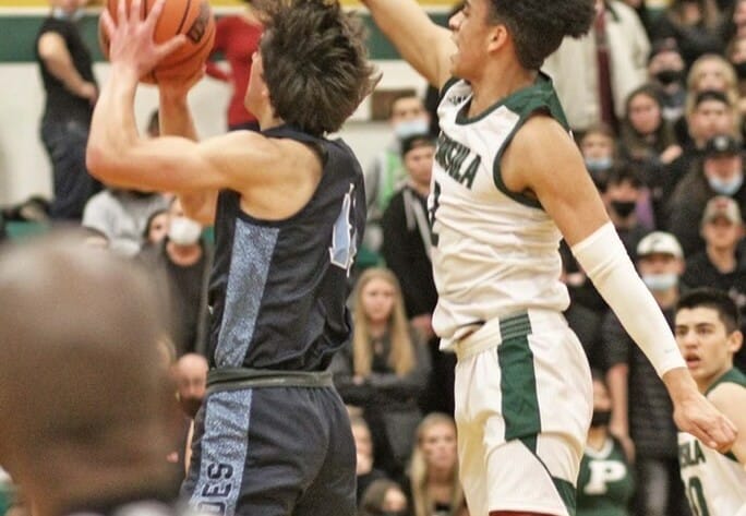 Peninsula's Marcus Douglas tries to block a layup attempt by Gig Harbor's Christian Parrish.