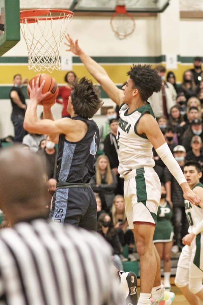 Peninsula's Marcus Douglas tries to block a layup attempt by Gig Harbor's Christian Parrish.