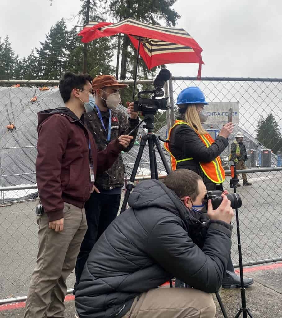 Communications personnel from Peninsula School District live stream the demolition of the old Artondale Elementary School on Jan. 3, 2022. At right is Artondale Principal Jessica Rosendahl (in blue hardhat).