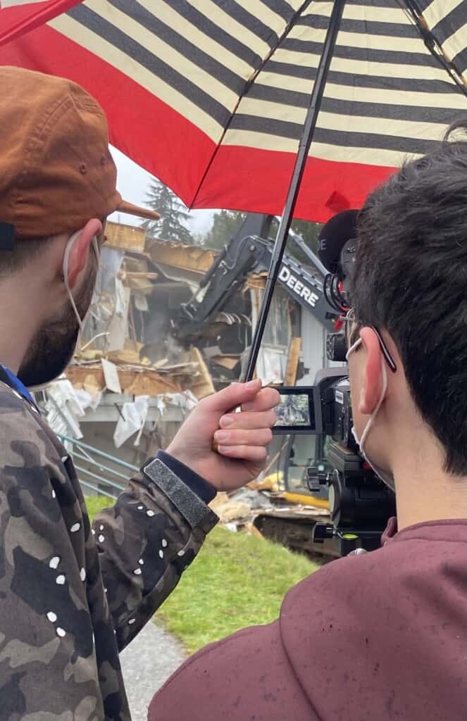 Communications personnel from Peninsula School District live stream the demolition of the old Artondale Elementary School on Monday. 