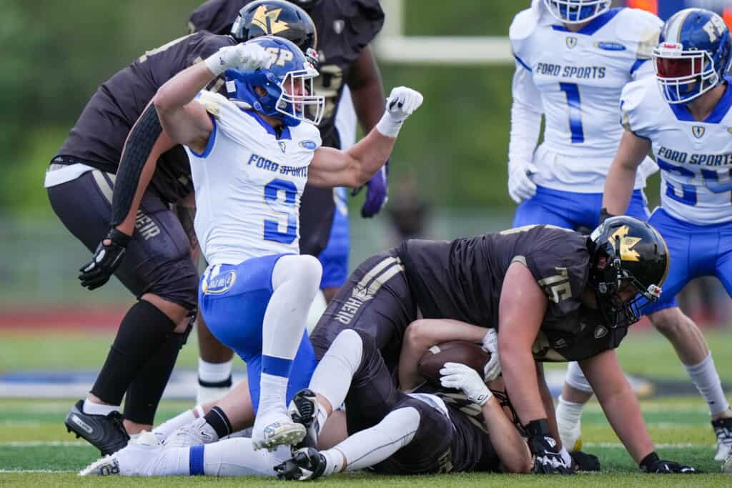 Hunter Cedarland celebrates making a tackle with his summer team.