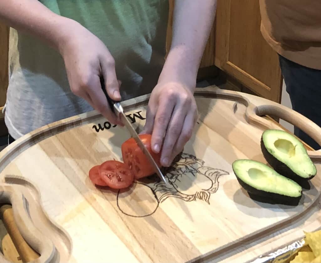 Mason Litts, a seventh grader at Key Peninsula Middle School, prepares nachos for his family’s dinner.