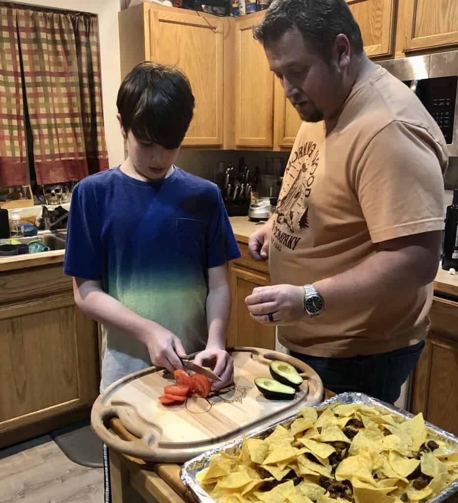 Mason Litts, a seventh-grader at Key Peninsula Middle School, prepares nachos with help from his dad, Dave West. Litts is part of the Cooking Crew, a twice-monthly virtual cooking club hosted by teachers Kate Schrock and Leah Smith. The club was founded as a social outlet for students during the pandemic and has continued as a sanctioned ASB activity.