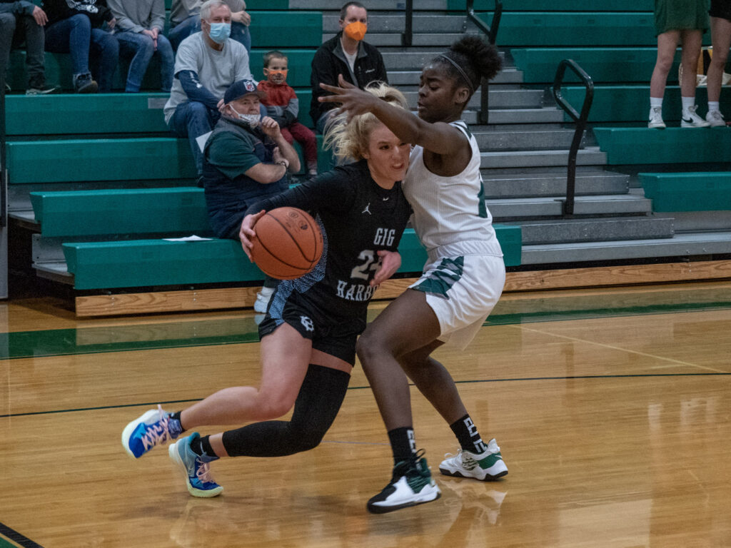 Baylee Young draws contact and drives hard to get by Peninsula's Grace Richardson in a game played earlier this year.