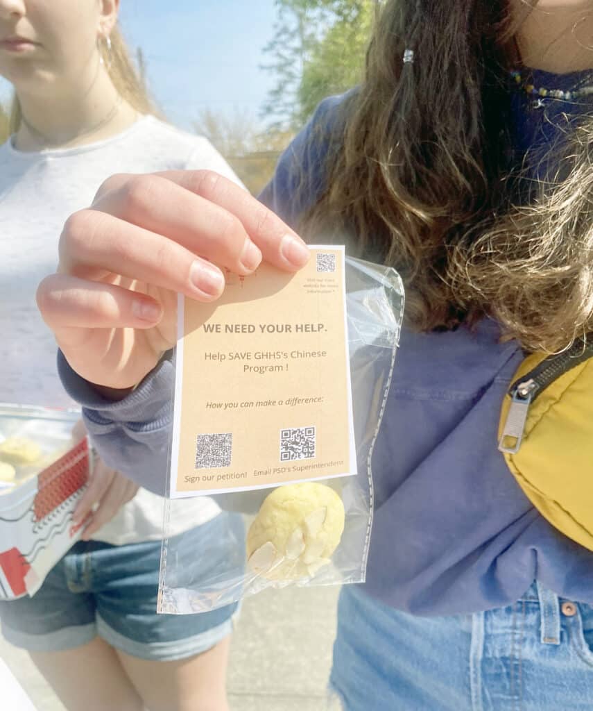 Gig Harbor High School Chinese language students handed out Chinese almond cookies and fliers to raise awareness of possible cuts in the program on Sunday, April 24, 2022, in downtown Gig Harbor.