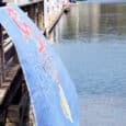 A Dragon Boats banner billows in the breeze while paddlers board their boats.