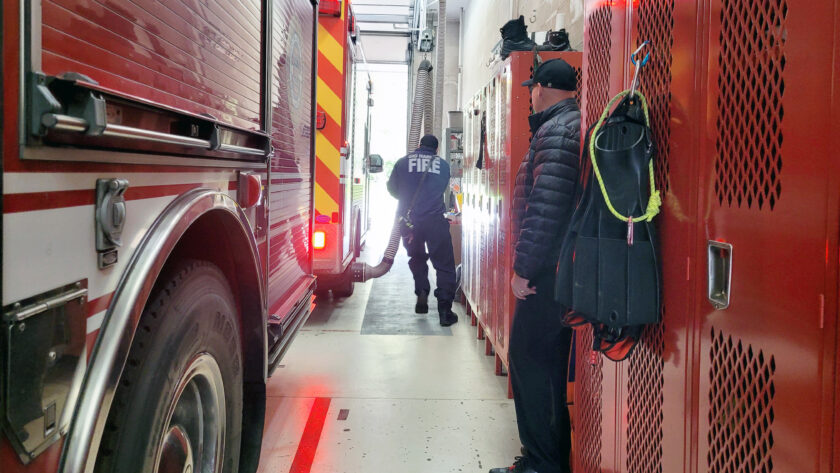 A firefighter prepares to respond to a call inside the cramped apparatus bay at Gig Harbor Fire and Medic One's Station 58 on Bujacich Road.