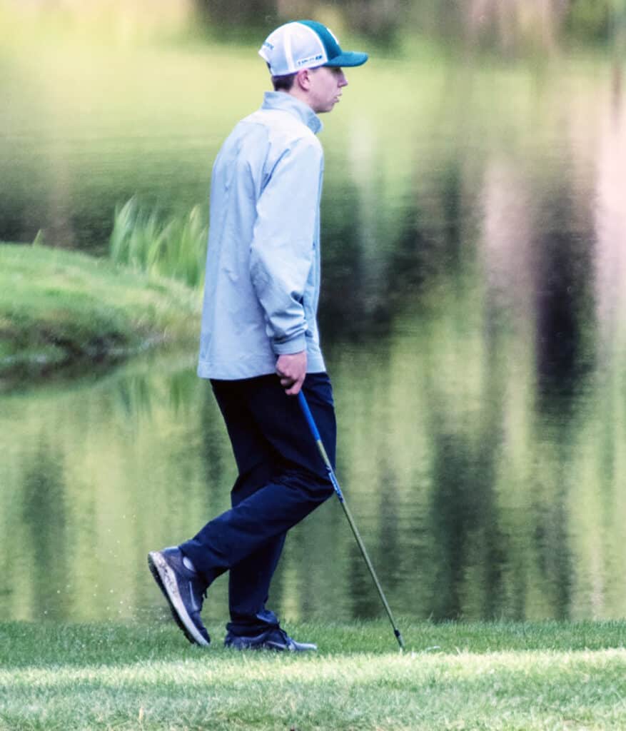 Kolton Waage, the No. 1 golfer for Peninsula High, concentrates before hitting a short chip shot on the green.