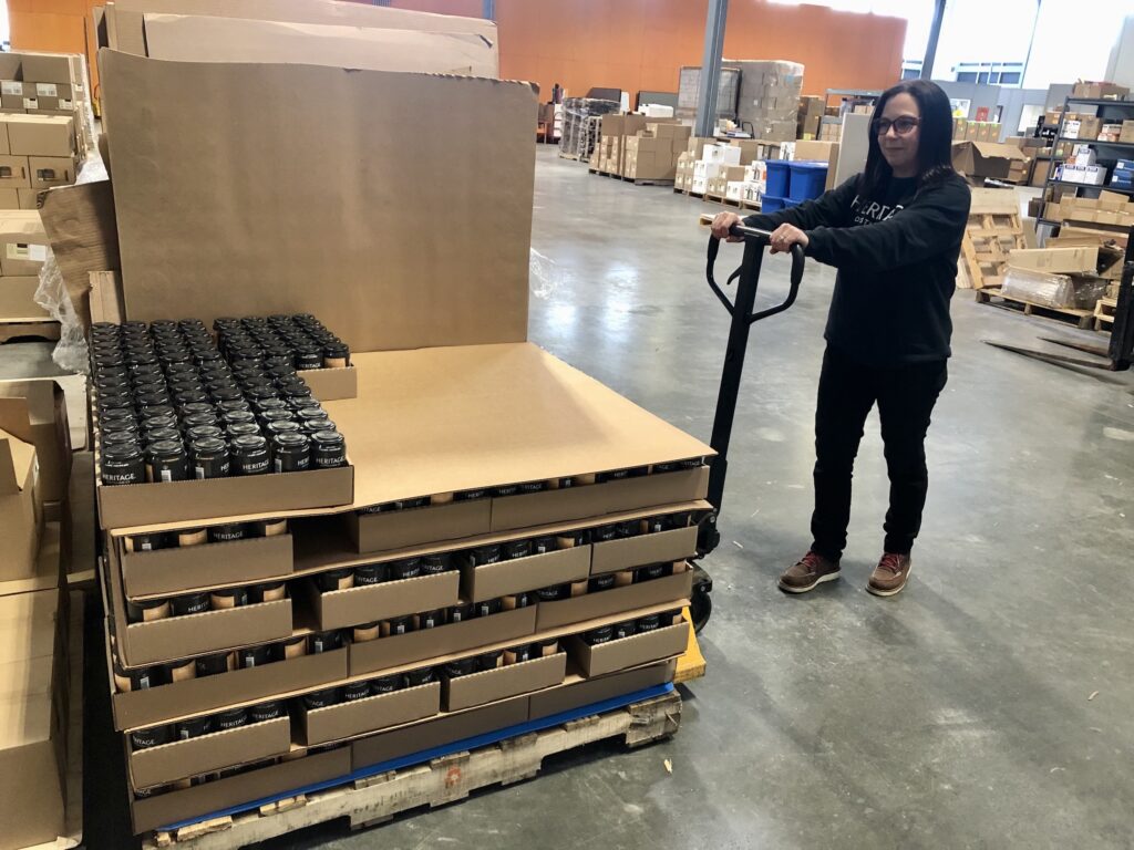 Merchandise Specialist Emily Cross moves a pallet of canned cocktails at Heritage Distilling Company in the Latitude 47 Commerce Center.