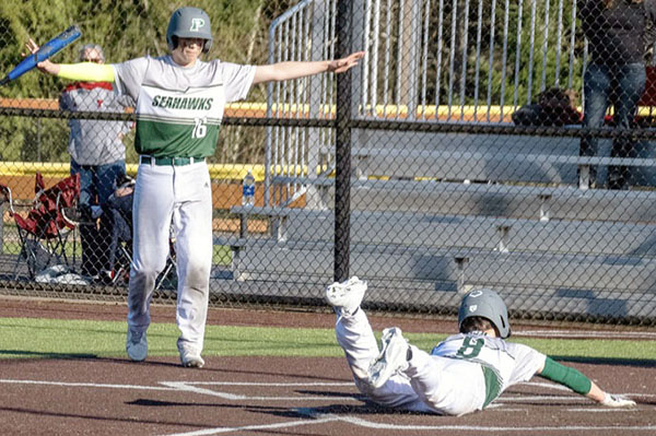 Troy Buchanan dives headfirst into home plate as his teammate takes over the umpire duties.