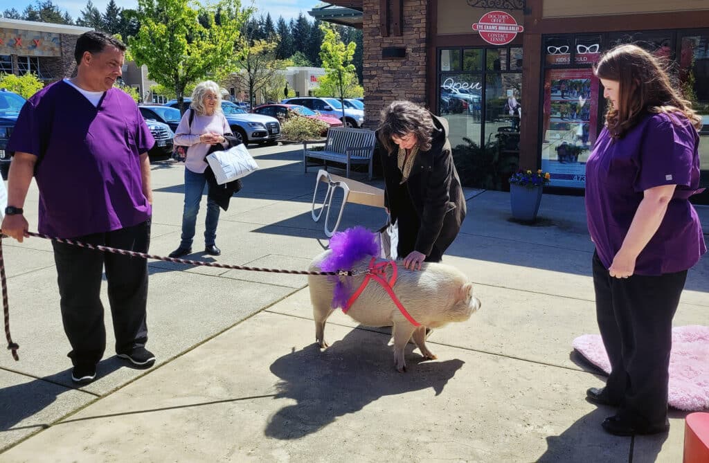 Shoppers in the Uptown Gig Harbor complex meet Gumdrop the pig, along with Robert Loehr and Dr. Kandi Moller.