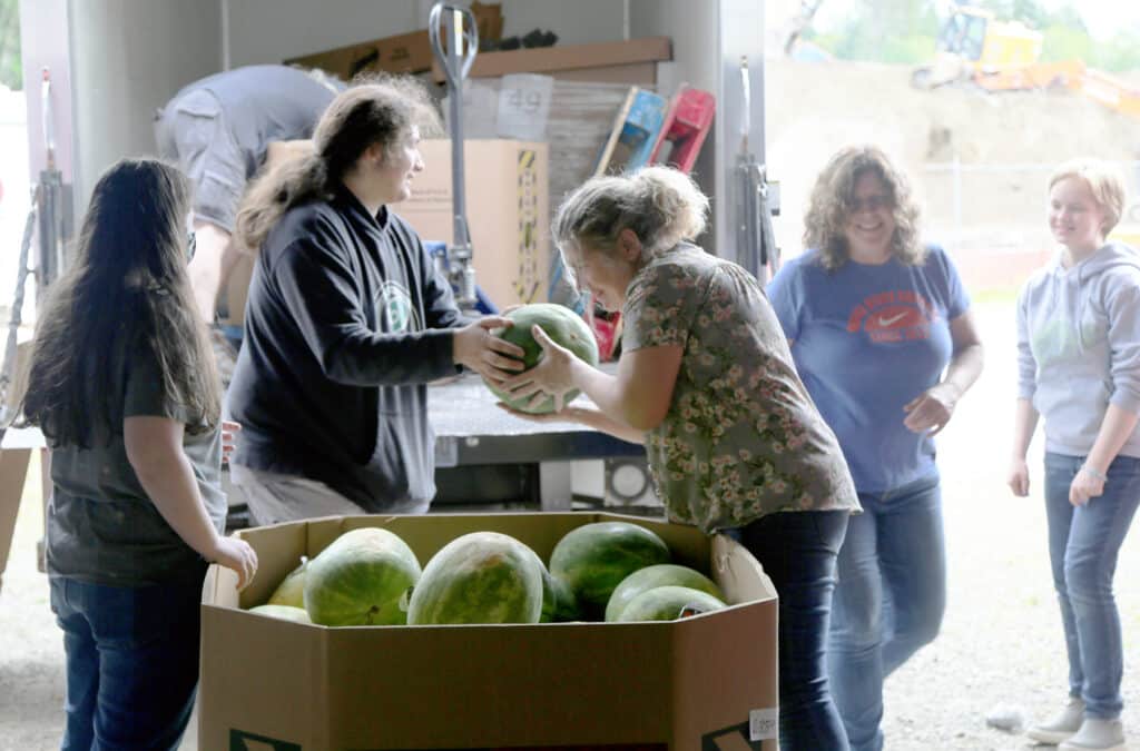 Volunteers unload watermelons delivered to the Food Backpacks 4 Kids Food Pantry on Wednesday, June 22, 2022.