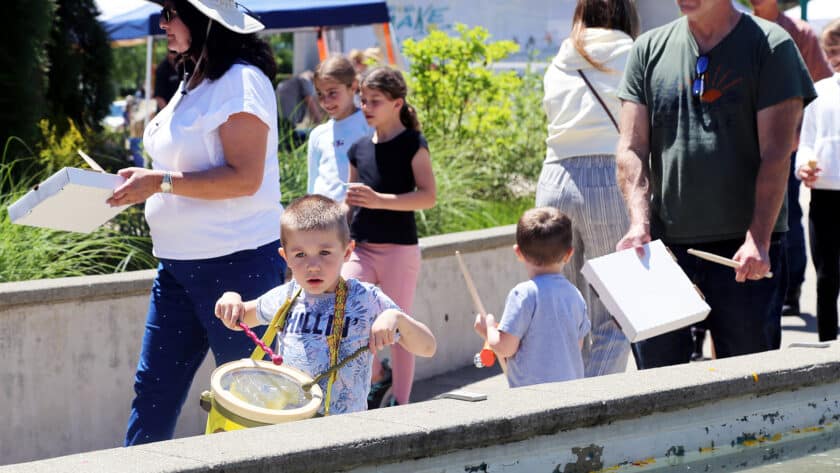 Spectators joined in the parade between stages, some using pizza boxes as drums, at Tuesday's Make Music Day at Uptown Gig Harbor.