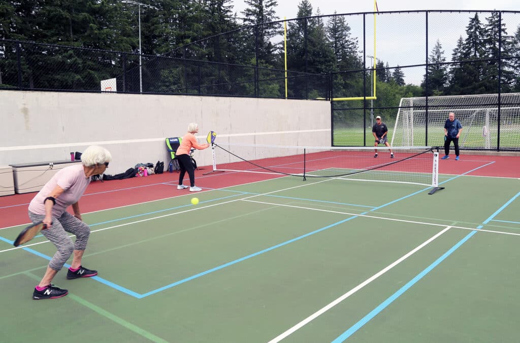 A pickleball player serves during a game at Sehmel Homestead Park.