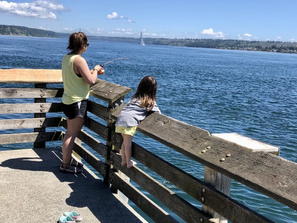 A woman and girl fish from Fox Island fishing pier.