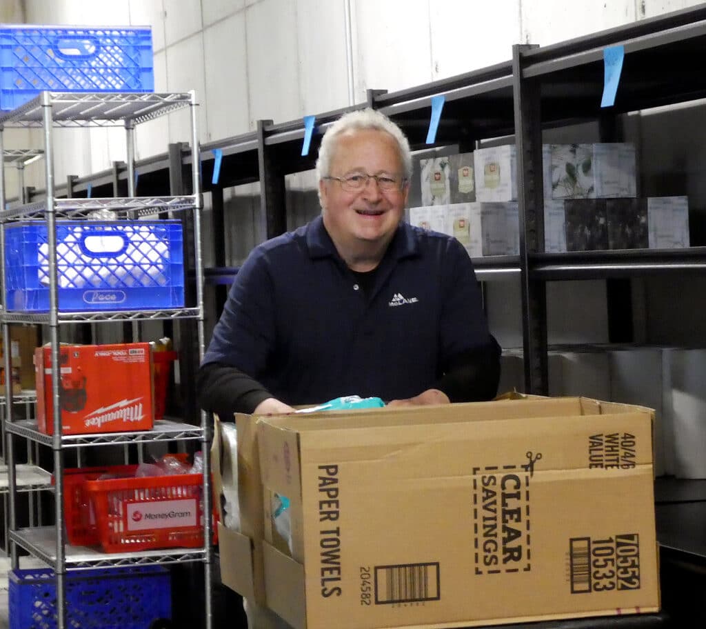 Gig Harbor Peninsula FISH volunteer Geoff Perry stocks shelves in the food bank's new building.