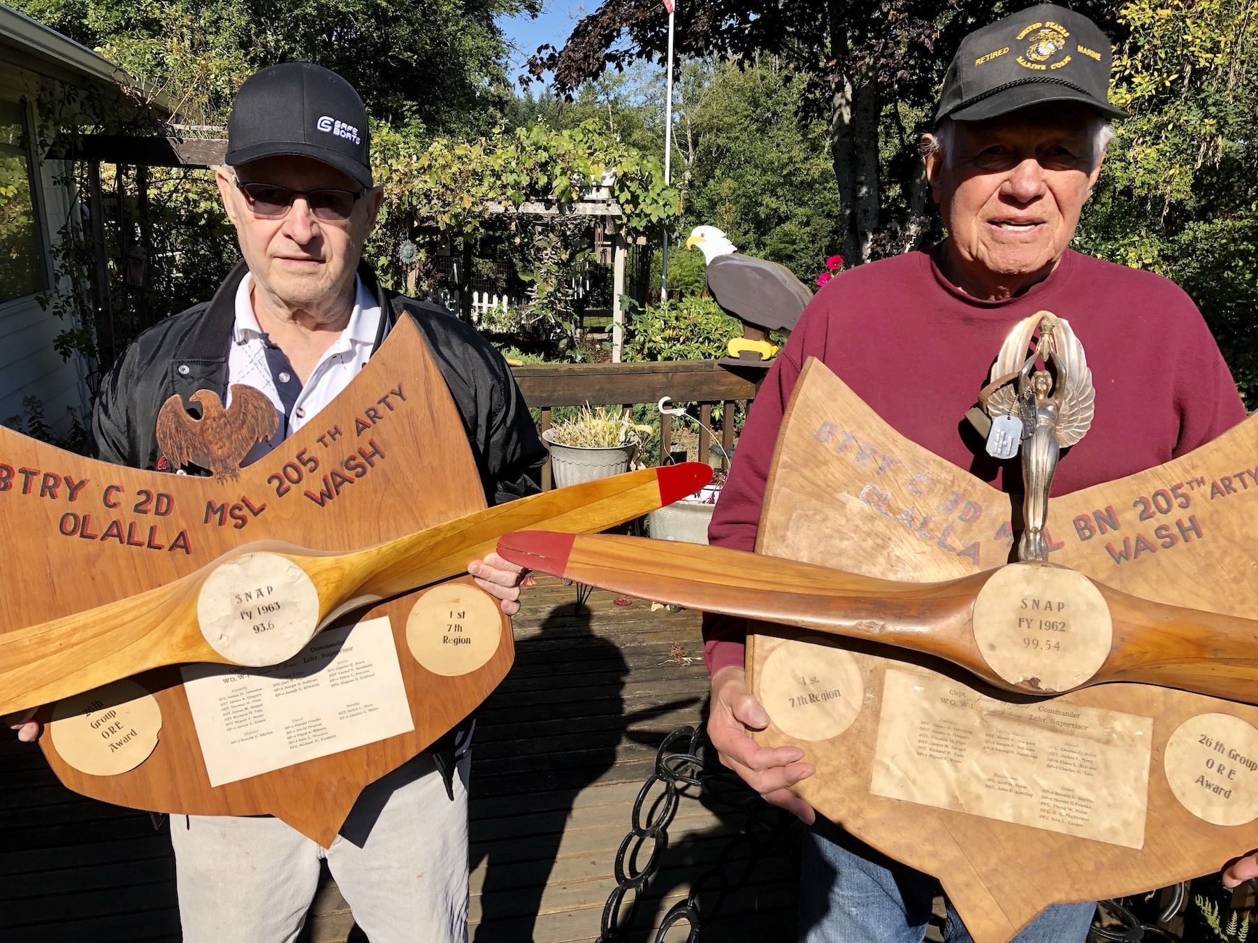 Carl Tinker, left, and Vince Romo hold trophies that the Olalla Nike team won at annual firing exercises in New Mexico. The propellers are from drones that the missiles blew up.